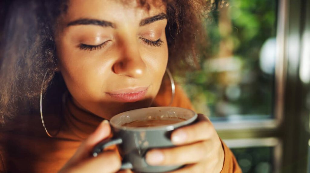 A person in Mallorca, holding a cup of coffee.